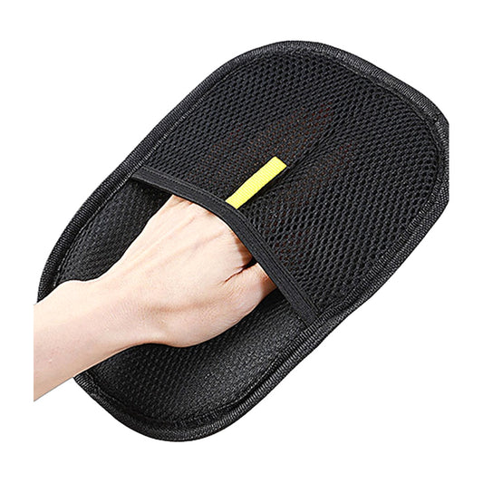 Black deshedding grooming glove worn on a hand, white background